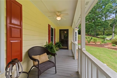 Wooden terrace featuring a ceiling fan, a yard, an