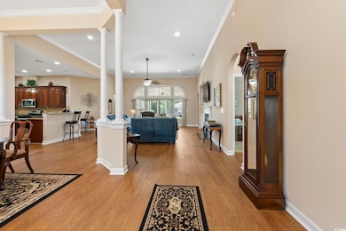 Living area with decorative columns, ceiling fan, crown molding, light wood-type flooring, and recessed lighting