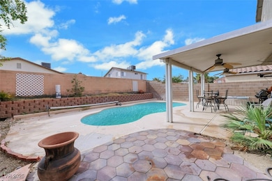 View of swimming pool featuring a patio area, a fenced backyard, and ceiling fan