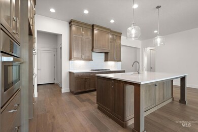 Kitchen featuring dark wood-style floors, tasteful backsplash, light countertops, stainless steel appliances, and recessed lighting