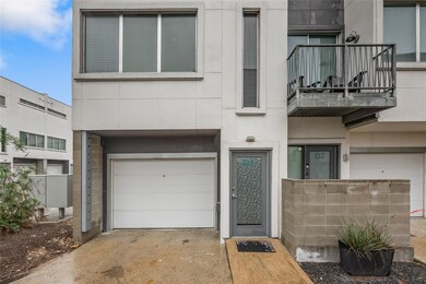 View of exterior entry featuring driveway, a gara