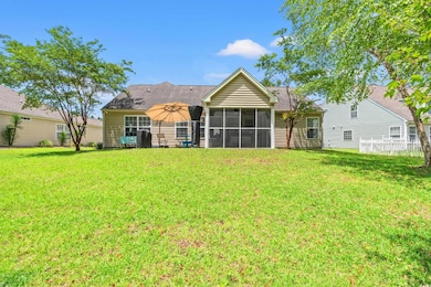 Back of property with a sunroom, a lawn, and a shingled roof