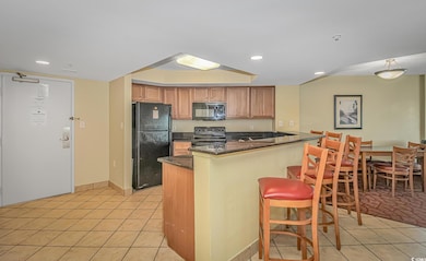 Kitchen with a kitchen bar, a tray ceiling, light 