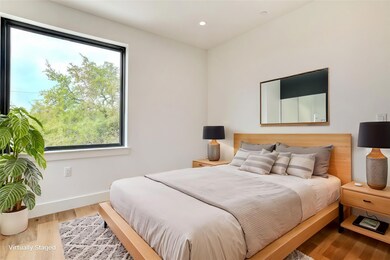 Bedroom with multiple windows, wood finished floo