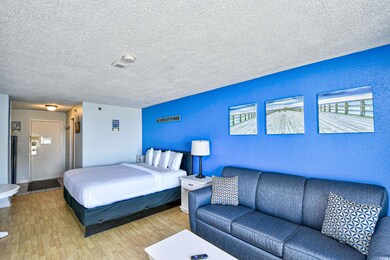 Bedroom with a textured wall, a textured ceiling, and light wood finished floors