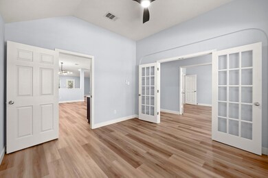 Spare room featuring french doors, ceiling fan, l