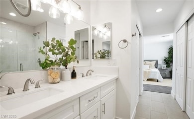 Ensuite bathroom featuring recessed lighting, a stall shower, double vanity, light tile patterned floors, and a chandelier