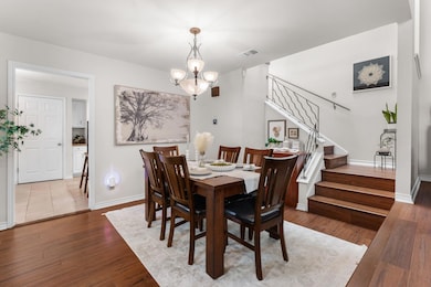 Dining area with stairs, a chandelier, and wood f