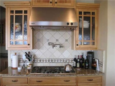 Cook's kitchen with 5 burner gas stove and pot filler.