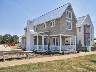 Rear view of house with covered porch and a lawn