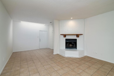 Unfurnished living room featuring a brick fireplac