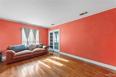 Living area with hardwood / wood-style flooring, baseboards, and crown molding
