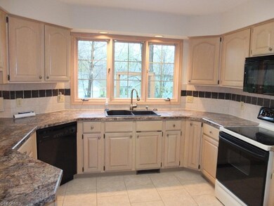 Fully applianced kitchen with tile floor.