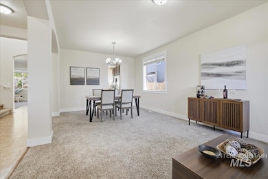 Dining space featuring light colored carpet, arched walkways, and healthy amount of natural light