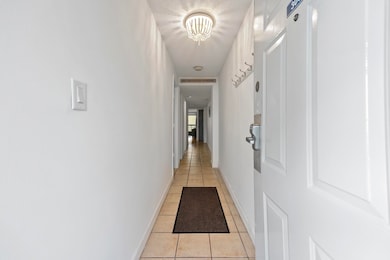 Hall featuring light tile patterned floors and a t