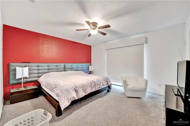 Carpeted bedroom featuring ceiling fan