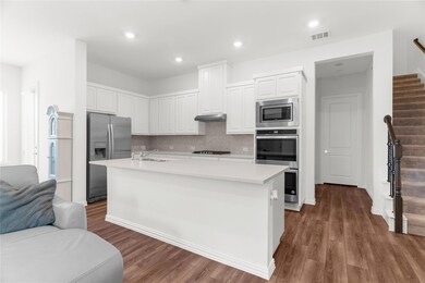Kitchen featuring a kitchen island with sink, stainless steel appliances