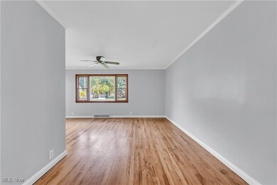 Spare room with ornamental molding, light wood-type flooring, and ceiling fan