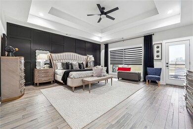 Bedroom featuring a tray ceiling, light hardwood /