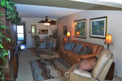 Living room featuring carpet and a ceiling fan