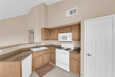 Kitchen featuring white appliances, visible vents,