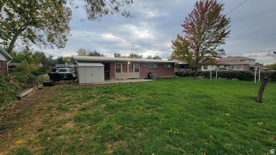 Back of property with a patio area, brick siding, and a shed