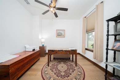 Playroom featuring a desk, light wood-type flooring, and a ceiling fan