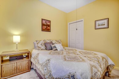 Bedroom with light colored carpet and a closet