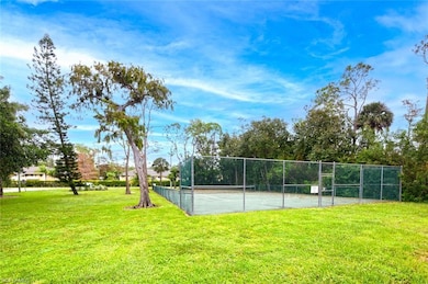 View of tennis court featuring a yard