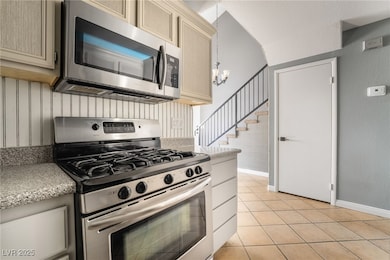 Kitchen with an inviting chandelier, appliances wi