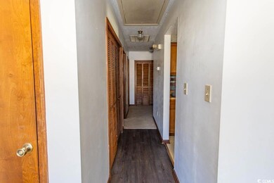 Hall featuring dark wood-style flooring, baseboard