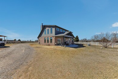 Rear view of house featuring brick siding, fence, 