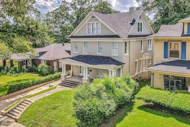 View of front of house featuring a shingled roof, a chimney, covered porch, a front yard, and brick siding