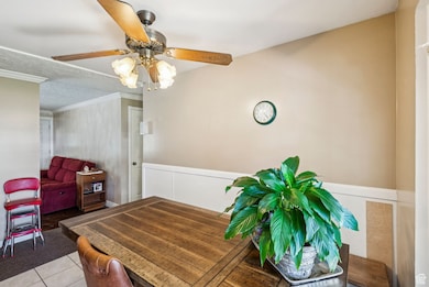 Dining area featuring ceiling fan, crown molding, and tile patterned flooring