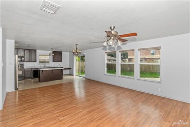 Unfurnished living room with a chandelier, light wood-style flooring, and a ceiling fan