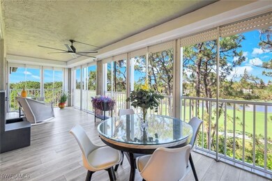 Sunroom with wood finished floors, a water view, and a textured ceiling