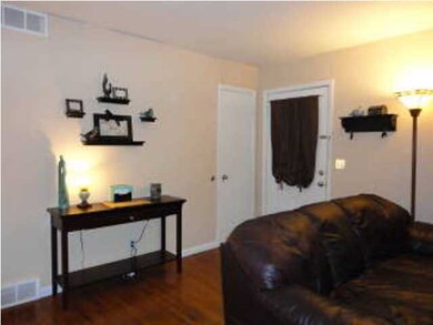 Front door, coat closet and hardwood floors in liv