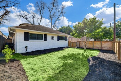 This fully fenced yard has plenty of room and fresh mulch on the flower beds.