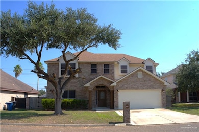 Traditional-style home featuring concrete driveway, brick siding, an attached garage, and a gate