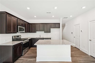Granite and Stainless Appliances with Stained Cabinets