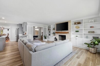 Living room with ornamental molding, light wood fi