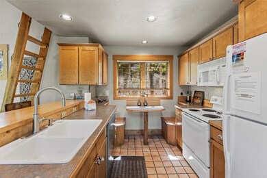 Kitchen with white appliances, brown cabinetry, li
