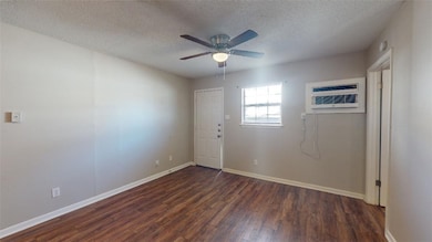 Spare room with a ceiling fan, a textured ceiling,