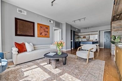 Living room featuring visible vents, wood finishe