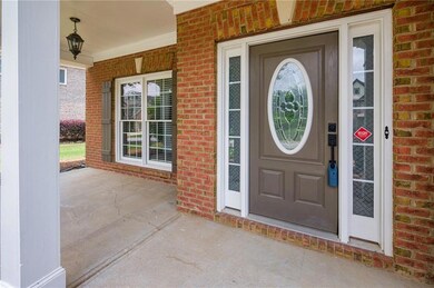 Doorway to property featuring brick siding and a porch
