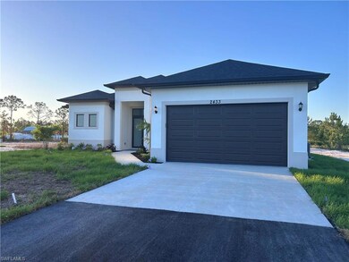 View of front of house featuring asphalt driveway,