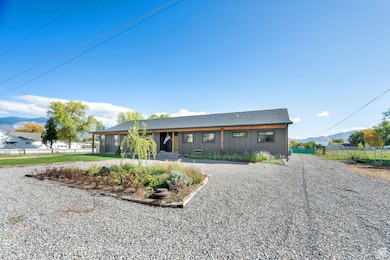 View of front of house with a mountain view, board and batten siding, roof with shingles, and gravel driveway