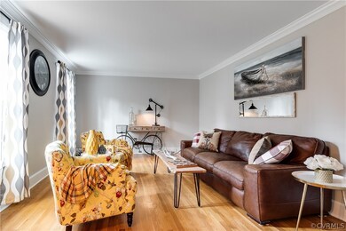 Large living room has hardwood floors, crown mould