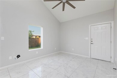 Empty room with ceiling fan, light marble finish floors, baseboards, and high vaulted ceiling