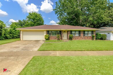Ranch-style home with a garage and a front lawn